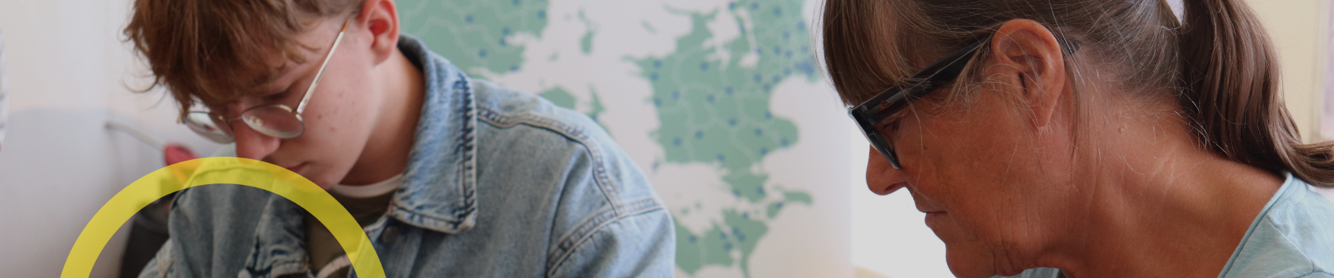 En middelaldrende kvinde arbejder med ler sammen med en ung person som del af et projekt.